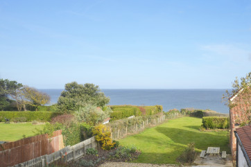 View over garden and onto sea from bedroom window