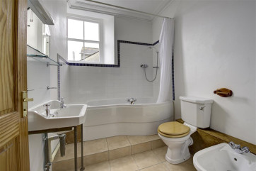 Dressing room leads to ensuite bathroom, with shower over