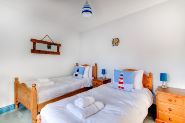 The pine wardrobe and dressing table match the twin beds