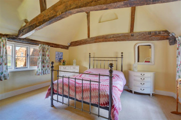 Bright, pretty and spacious bedroom with exposed beams.