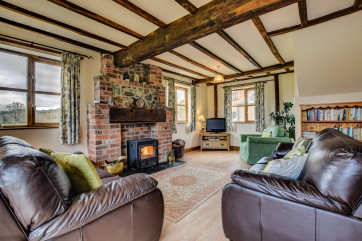Large spacious oak beamed lounge with warm, welcoming log burner