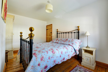 Delightful double bedroom with wrought iron double bed and pine floorboards