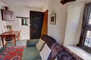 The impressive dark oak entrance door opens direct into the small sitting room