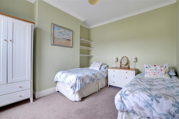 This twin Bedroom has a chest of drawers and wardrobe for storage.
