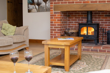 Brick fireplace and woodburner makes an attractive focal point.