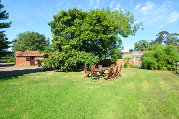 Shared open-plan lawned area with garden furniture and barbecue, ideal for al fresco dining