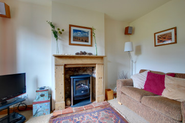 The sitting room has an attractive fire place with an electric living flame fire that supplements the gas central heating and gives a cosy feel
