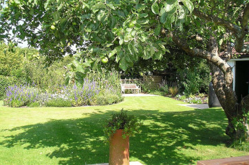 The property is situated in grassy areas, providing plenty of space for parking at the front and relaxing at the rear.