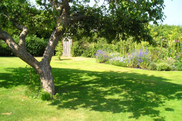 The property is situated in grassy areas, providing plenty of space for parking at the front and relaxing at the rear.