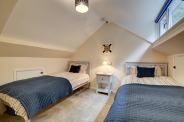 Further steep stairs to the second floor opens out into a second attractive bedroom with sloping ceiling and twin beds