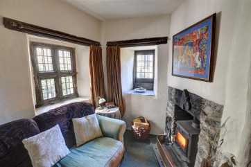 The cottage has a woodburning stove in the small stone fireplace