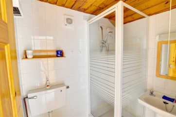 Shower room with shower, toilet and washbasin.