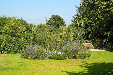 The property is situated in grassy areas, providing plenty of space for parking at the front and relaxing at the rear.