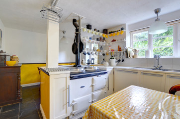 Quirky looking fitted kitchen/diner with oil-fired Aga and fridge/freeze