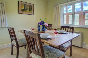 The dining room has an oak extending dining table and six chairs, and windows to two sides