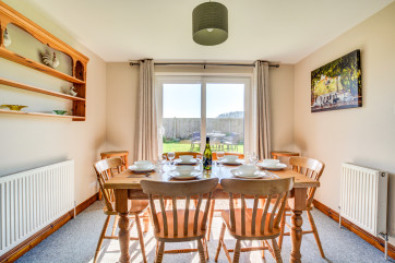 The dining area in the kitchen is at one end and there is a dining table and chairs and French doors that lead to the garden. 
