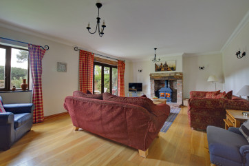 Light and spacious sitting room with large wood burner and french doors to the garden