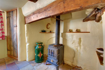 The little wood burner set in the large open fireplace of the dining room.