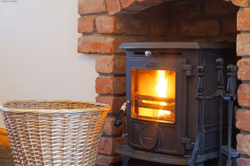 Large, warm and inviting lounge with comfortable seating & logburner
