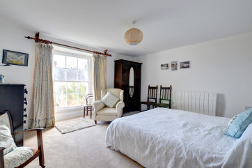 Plenty of room in the bedroom, contains a king size bed and features its own original fire place