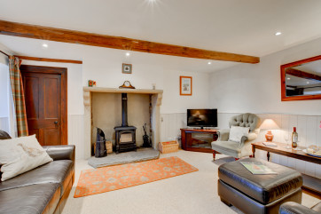 Spacious lounge with solid fuel stove and countryside views