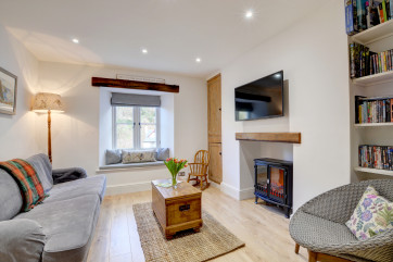 The open plan living area with comfy settee, and cushioned window seat ideal for enjoying the views