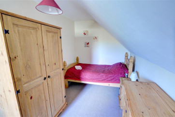 Twin bedroom has chest of drawers and wardrobe