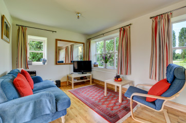 A light and bright sitting room with colourful furnishings.