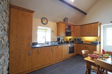 A character oak kitchen with slate floor and a farmhouse pine table