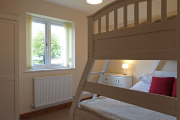 Double bed at the bottom and single bed above, along with a chest of drawers.