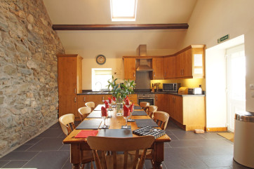 A character oak kitchen with slate floor and a farmhouse pine table
