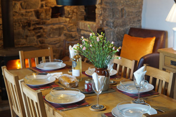 Dining table in front of a beautiful inglenook and woodburner