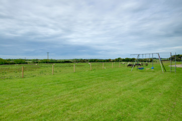 Play area to the rear of the property with its own swings and picnic furniture