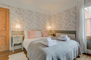 First floor bedroom with king-size bed and feature fireplace