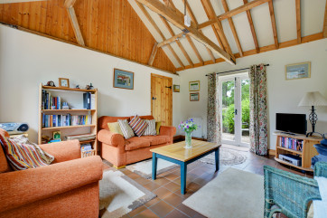 The sitting room attractively furnished with comfortable seating, TV, Freeview, video, woodburner and French doors leading to the patio garden. 