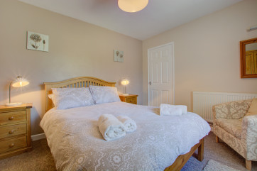 A comfortable double bedded room with television and plenty of storage space.