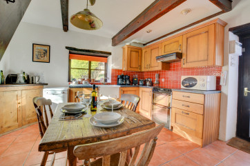 Large farmhouse kitchen with most major appliances and lovely character beams and tiled floors