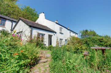 This delightful semi-detached character cottage is set within a canopy of ancient trees with an abundance of ferns and wild flowers