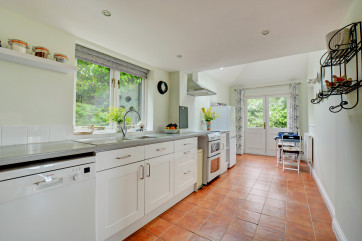 Light and airy kitchen with  built-in electric oven and hob, fridge/freezer, dishwasher, microwave and bistro table and chairs for two