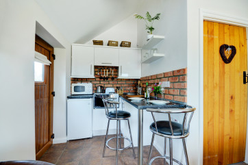 The kitchen area includes a handy breakfast bar and stools.