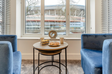tub chairs and table in king bedroom with views over the Principality Stadium  at Hafan y Ddinas Cardiff Apartment 2