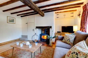Cosy sitting room with TV and delightful wood burner