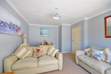 The sitting room is a light and airy room, perfect for relaxing in after a day at the beach