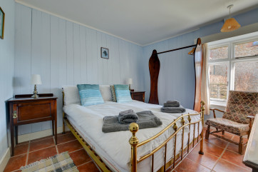 A tastefully furnished double bedroom with a brass bedstead double bed 