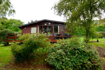 The lodge has a balcony to the front, with garden furniture