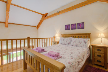 On a mezzanine floor above, the stylish bedroom has a pristine ensuite shower room
