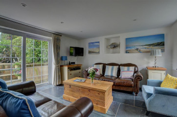 The lovely sitting room overlooks the garden with patio doors leading out onto the patio