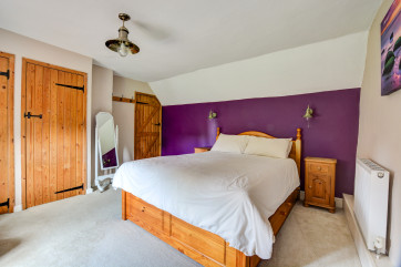 An image of bedroom 1 with it's king size bed and en-suite bathroom.