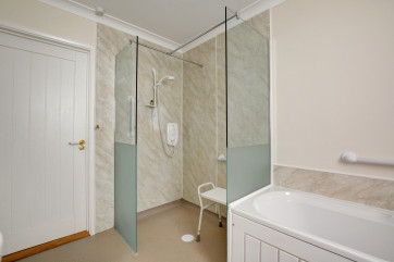  View of wet room with seat and grab handles