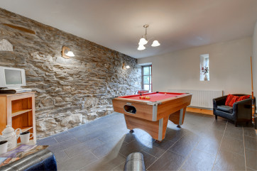 Games room offers a separate living area with leather chairs & TV